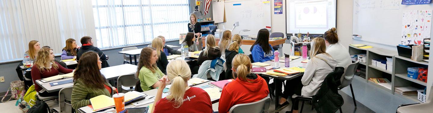 Teacher lecturing to a class using the whiteboard